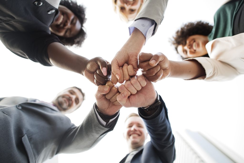 Programa de liderança oferece aos líderes de empresa, pessoas em circulo unindo as mãos como uma equipe